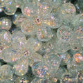 A close-up pile of blue, flower-shaped beads filled with iridescent glitter and small rhinestones in the center.