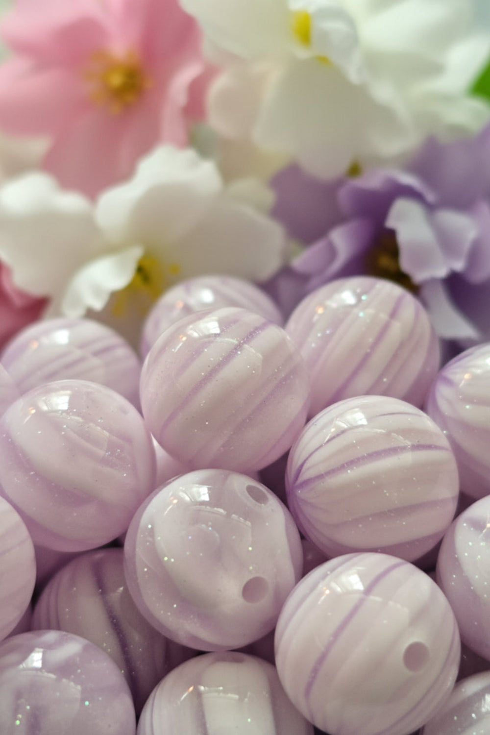 Close-up of purple and white marbled beads in a container