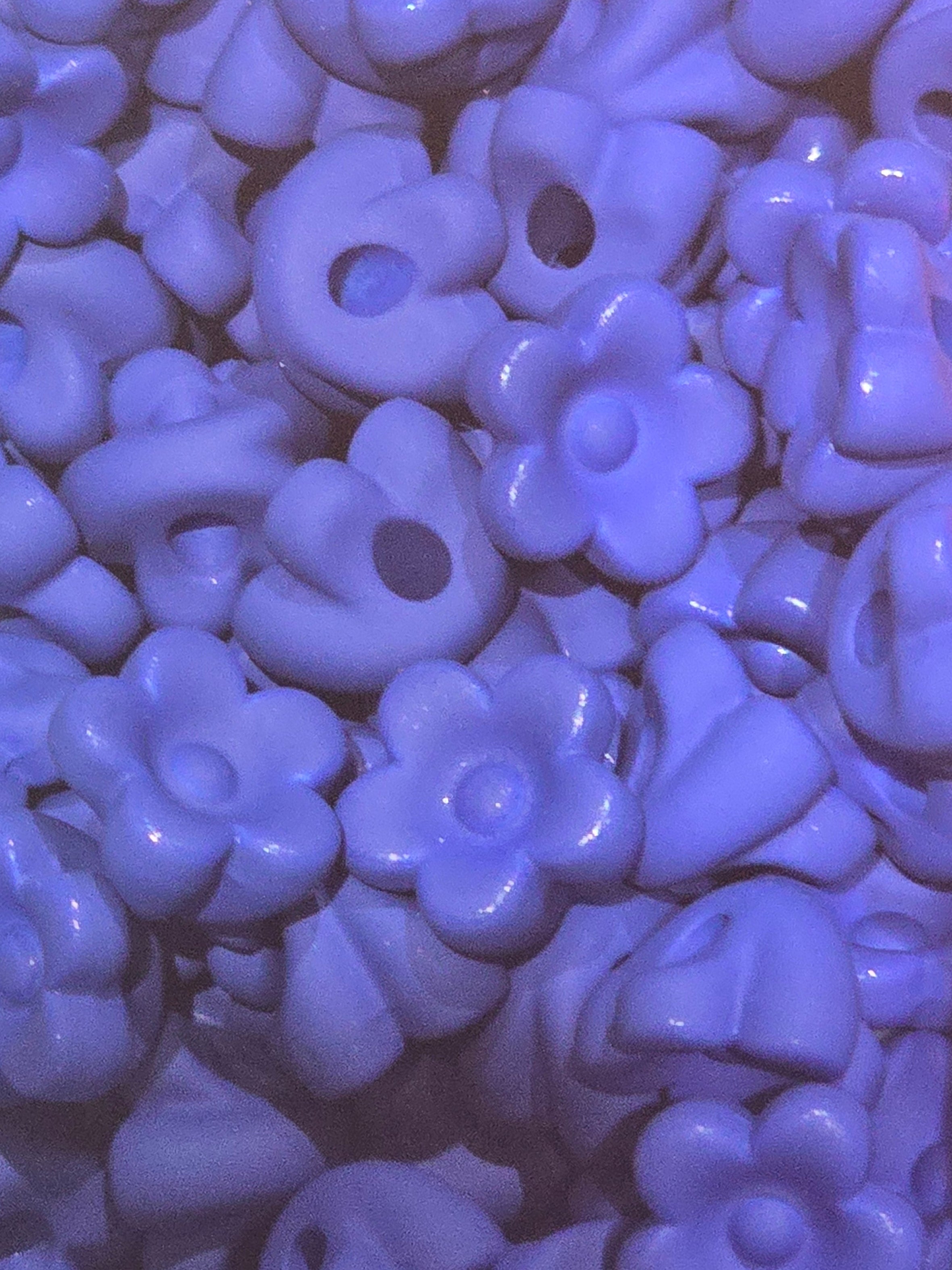 A close-up pile of small white flower-shaped beads will also fit pens
