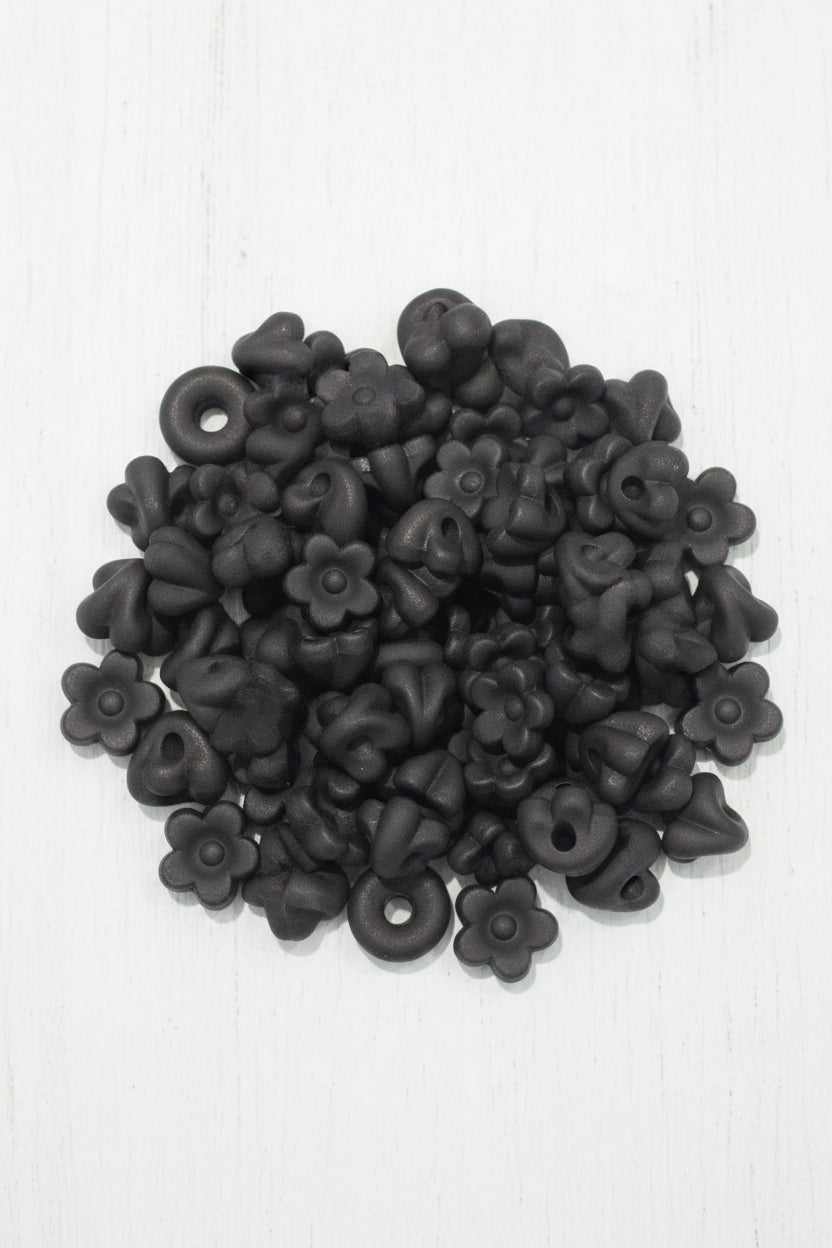 A close-up pile of small white flower-shaped beads will also fit pens
