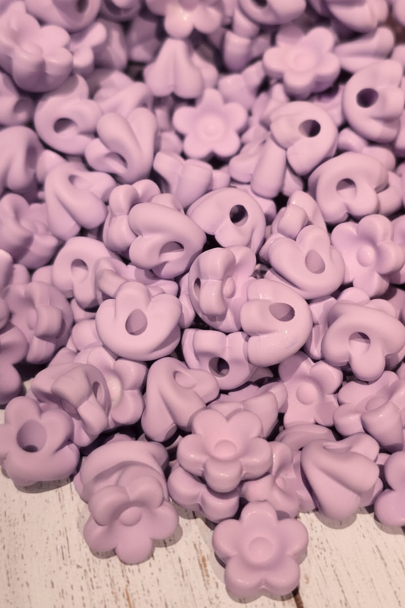 A close-up pile of small white flower-shaped beads will also fit pens