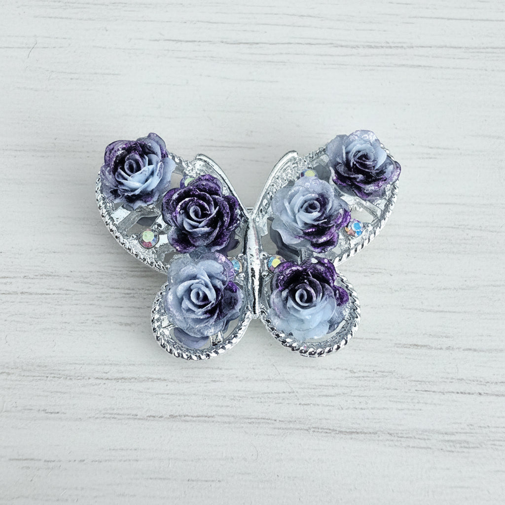A butterfly-shaped brooch featuring embossed lavender and white roses.