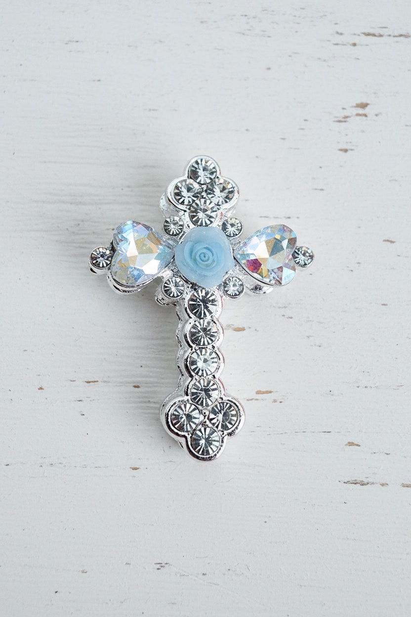 A silver-toned cross-shaped bead embellished with clear rhinestones, a rose and iridescent glass heart-shaped crystals.