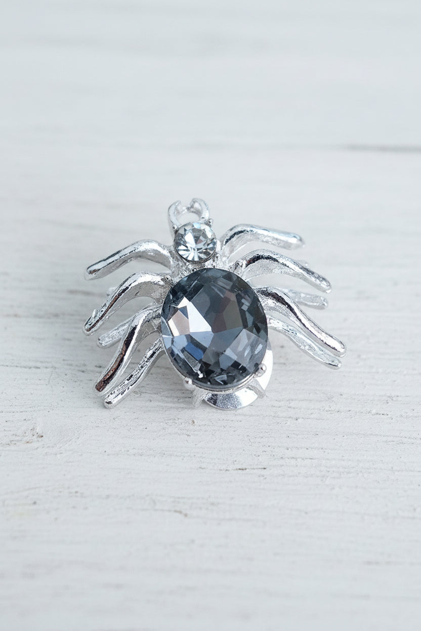 A spider-shaped silver bead with a faceted black glass crystal