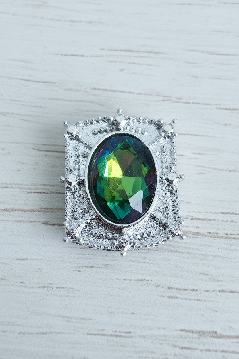 A silver-toned bead featuring a square halo setting with a central oval-cut iridescent glass gemstone that shifts between green, blue, and yellow.