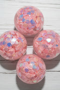 Pink resin beads filled with small iridescent heart-shaped confetti.