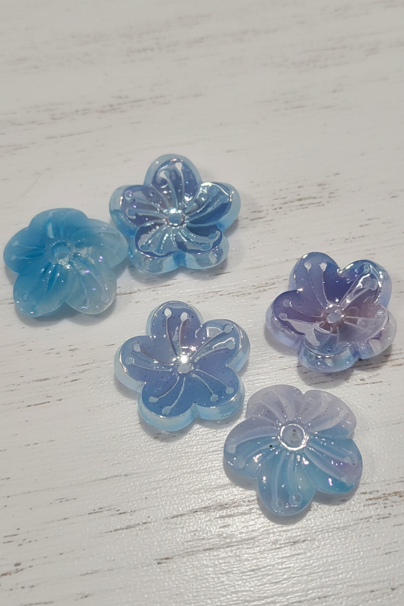 Translucent flower-shaped resin charms in shades of light blue, lavender, and aqua.