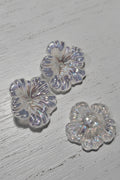 Three clear, glittery flower-shaped beads.