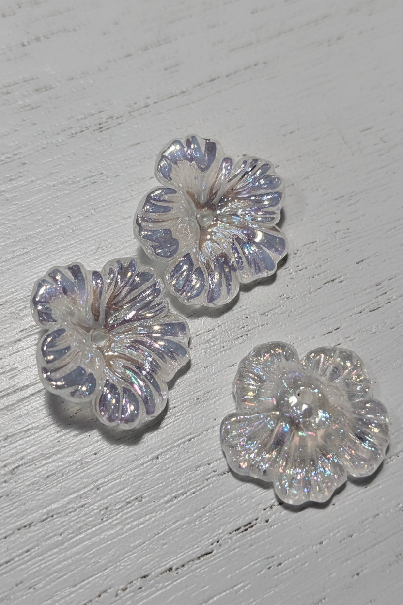Three clear, glittery flower-shaped beads.