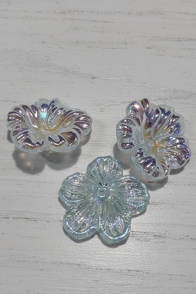 Three iridescent flower-shaped glass beads with a holographic finish.