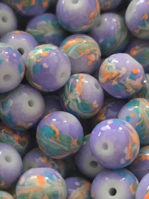 A close-up pile of round glass beads with a glossy finish, featuring a marbled pattern of lavender purple, teal blue, and orange swirls.