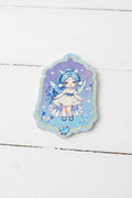 An acrylic tag featuring an anime-style illustration of a blue-haired girl in a white dress on a purple starry background.