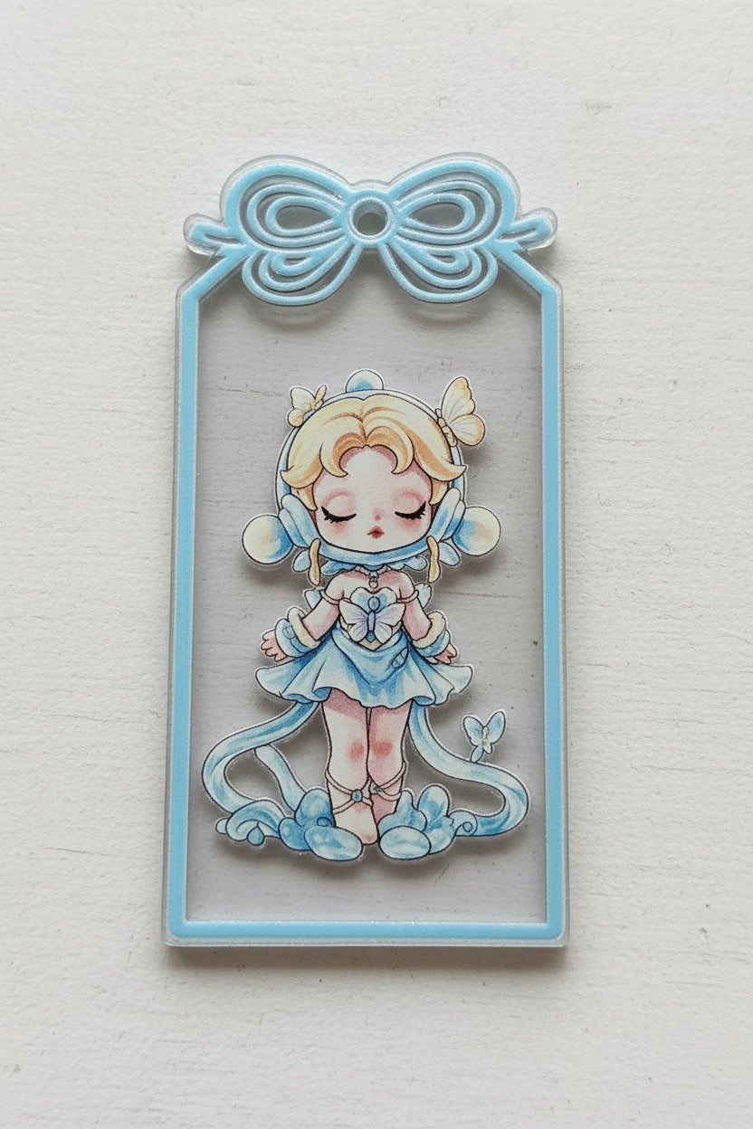 A rectangular acrylic tag featuring a  girl character in a light blue and white outfit on a dark background, with a decorative bow.