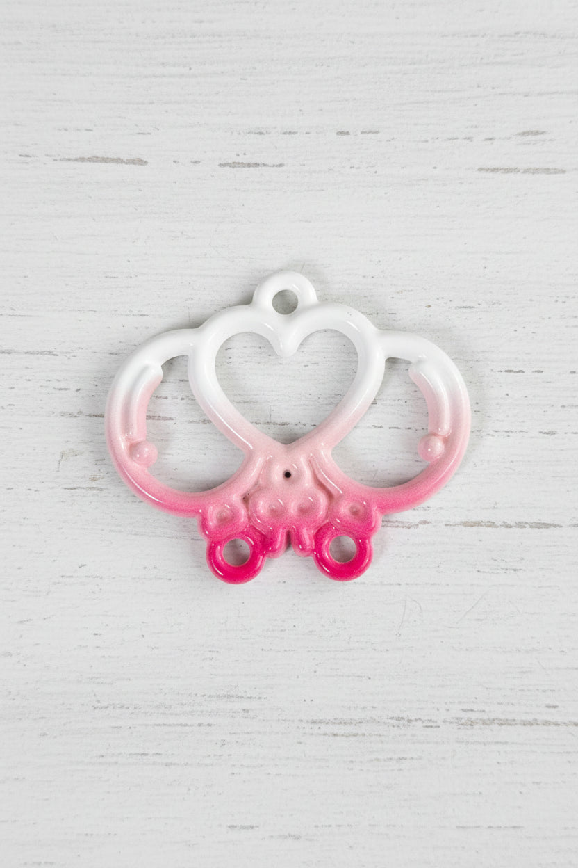 A small metal decorative butterfly-shaped accessory with a white and light blue body and pink accents.