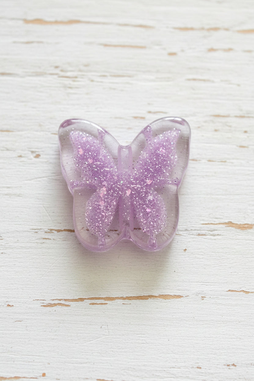 A translucent purple glitter butterfly-shaped beads.