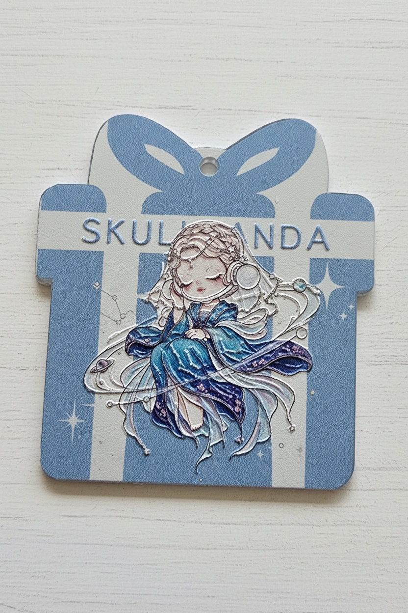 A decorative acrylic tag featuring a blue and white striped background, vertical text reading 'SKULLPANDA,' and an illustrated fairy-like figure in blue and white with star accents.