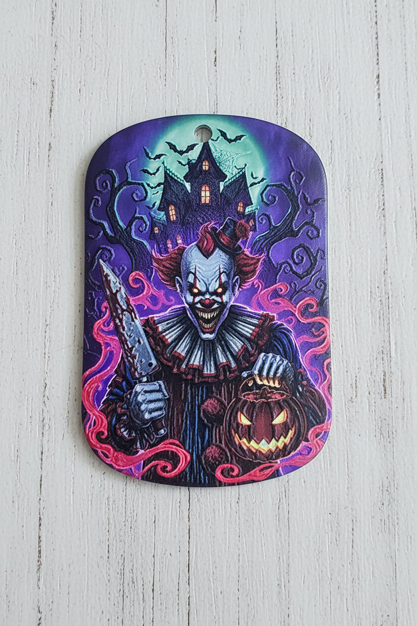 An acrylic tag featuring a spooky Halloween design with a clown, a jack-o'-lantern, a haunted house, and swirling purple and pink magic against a blue and green night sky.