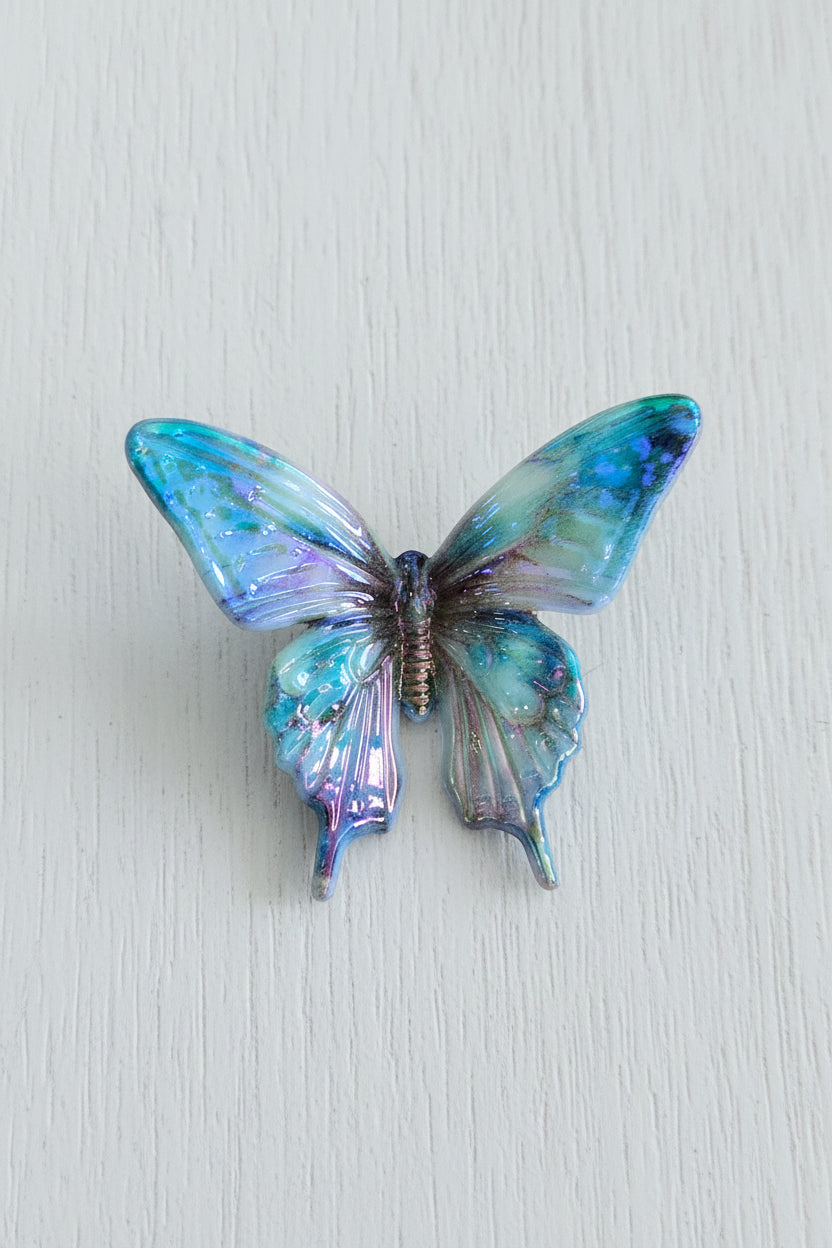 A butterfly-shaped bead with iridescent blue, green, and purple wings.