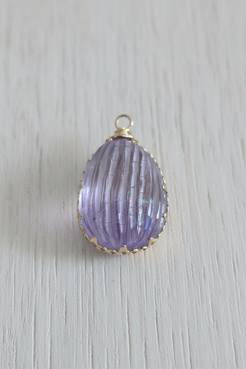 A teardrop-shaped lavender purple cabochon pendant with gold bezel setting.