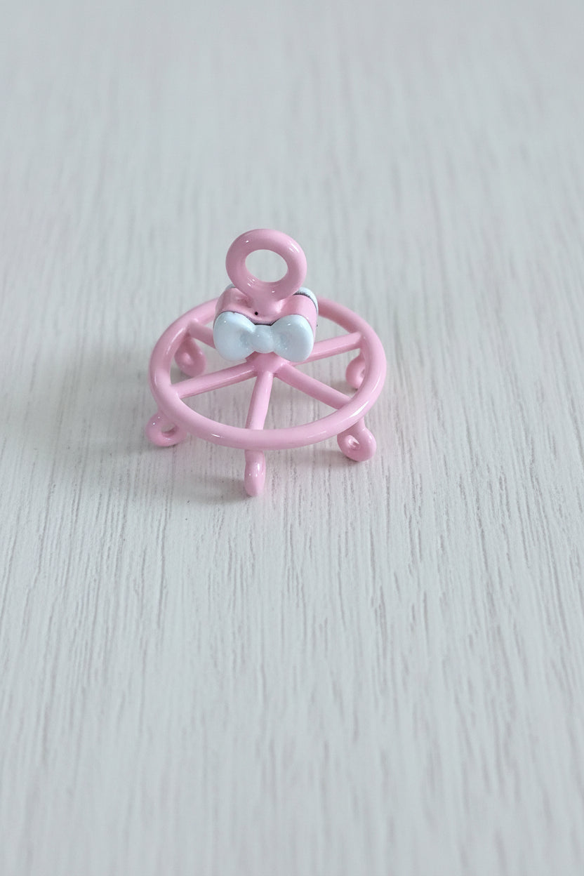 A small pink decorative wheel accessory with a white bow detail.