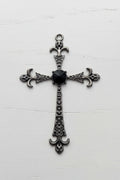 An ornate silver-toned metal cross pendant with a central black oval stone.