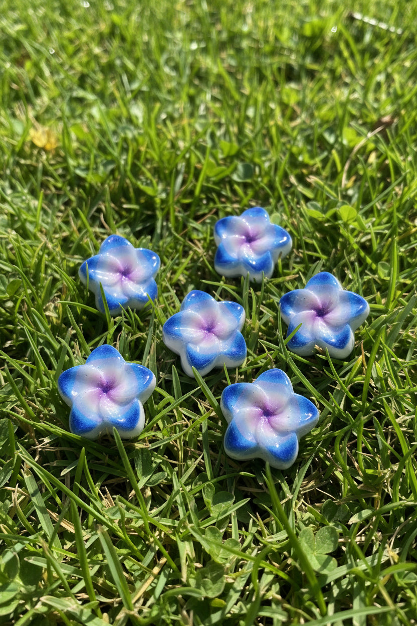 Glossy acrylic flower-shaped beads with blue, purple, and white details.