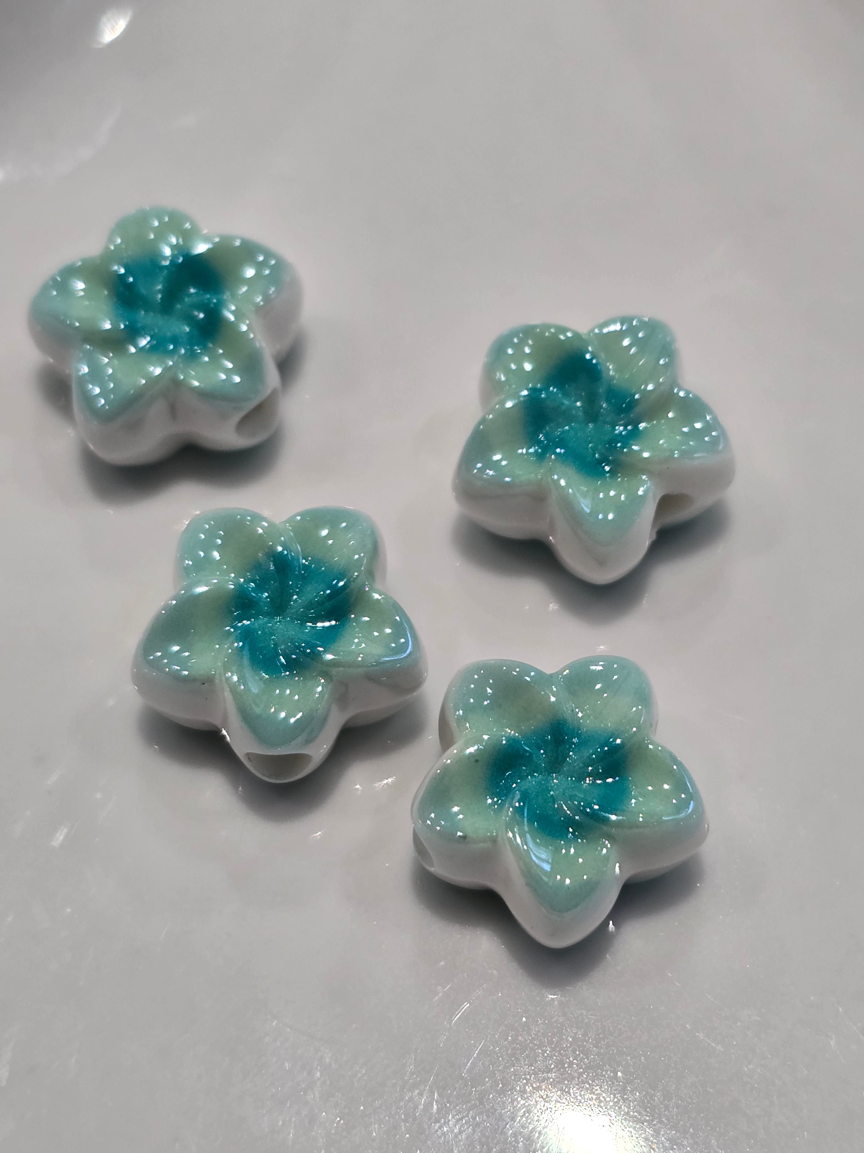 Acrylic flower-shaped beads with white petals and a sparkling light blue centre.