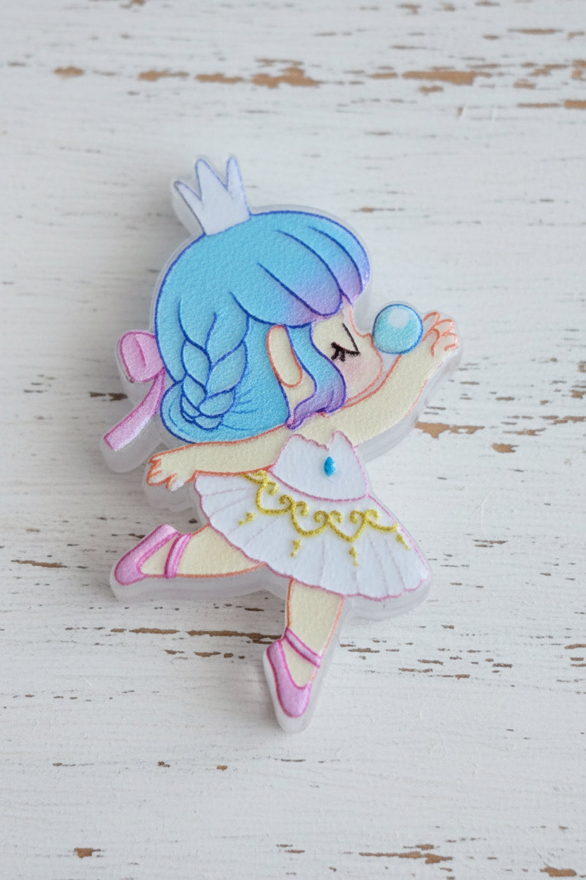 An acrylic bead shaped like a dancing anime-style girl with blue hair, a white dress, pink accents, and a blue bubble.