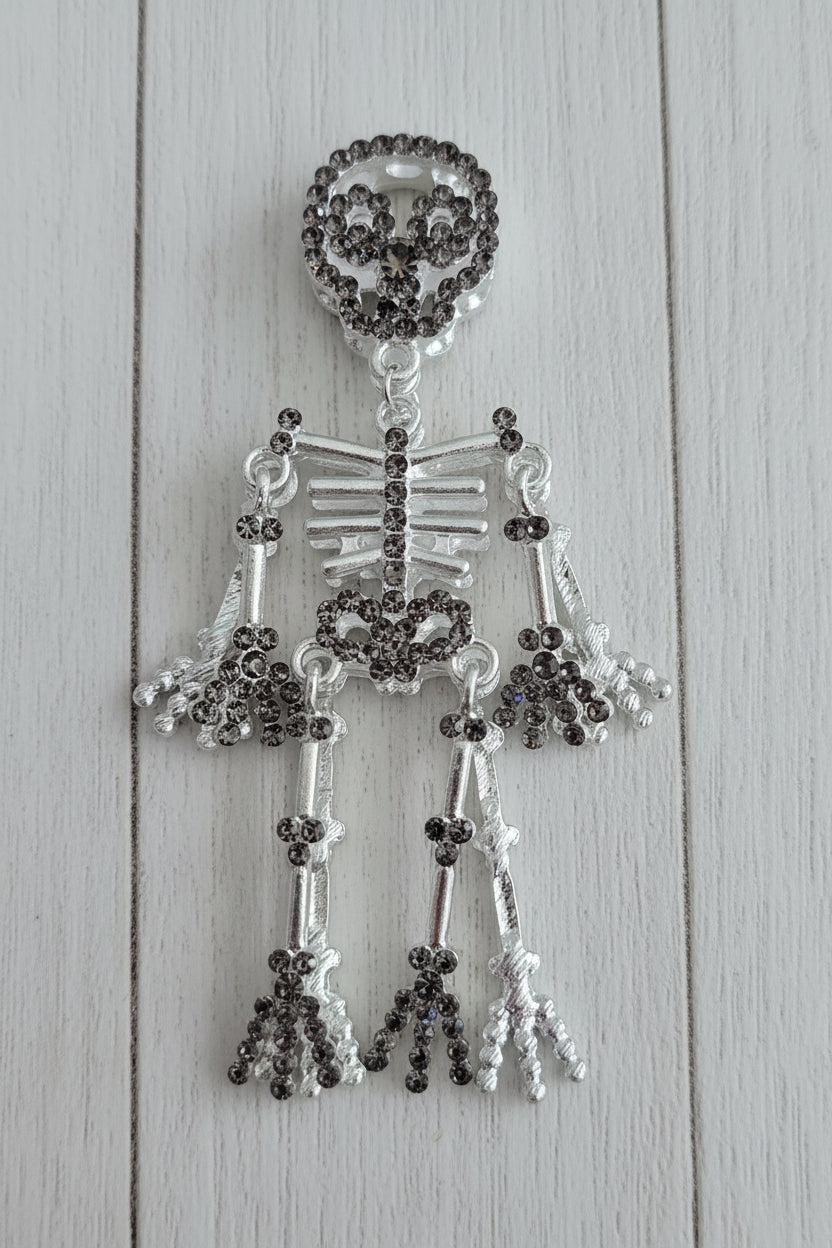 A skeleton-shaped bead made of silver-toned metal and dark gray rhinestones.