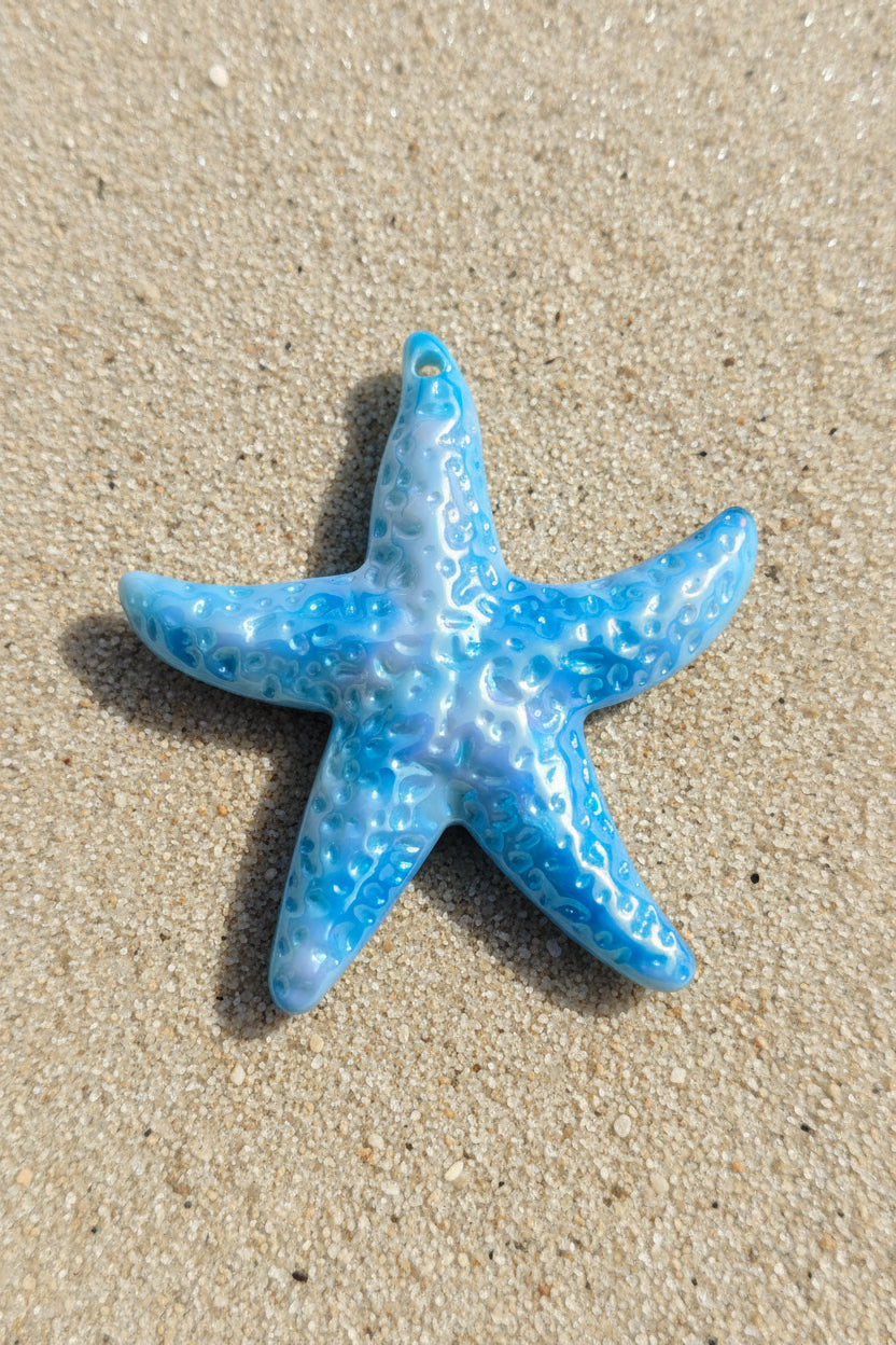A glossy blue starfish-shaped acrylic pendant with a textured, bubbly pattern.
