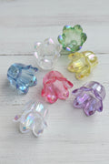 Six  iridescent flower-shaped beads in assorted colors including blue, clear, green, yellow, pink, and purple.