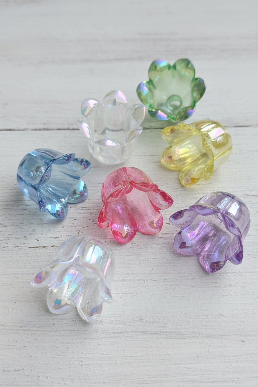 Six  iridescent flower-shaped beads in assorted colors including blue, clear, green, yellow, pink, and purple.