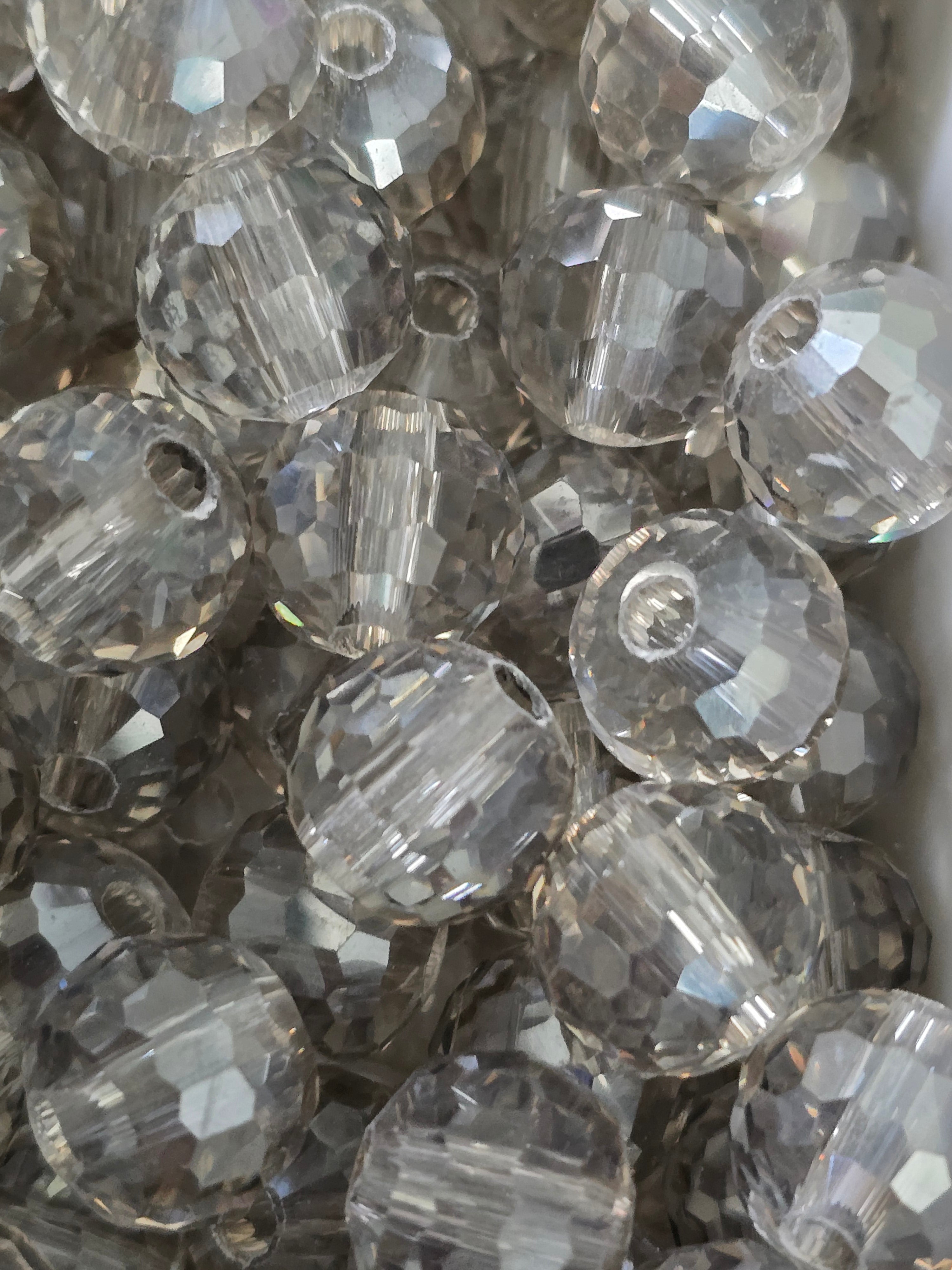 A close-up pile of faceted glass smokey grey beads.