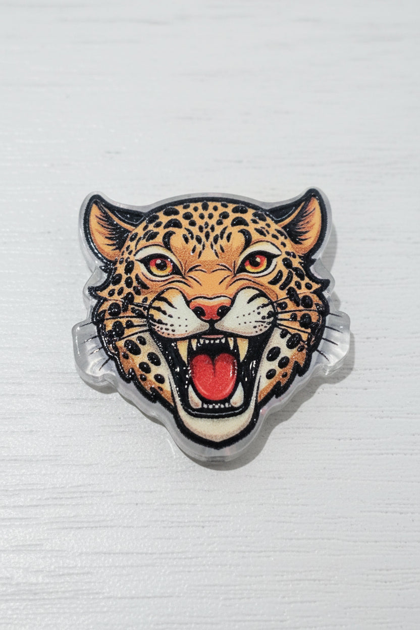 A leopard head acrylic bead with an open mouth showing a red tongue, detailed with black spots on a tan background.