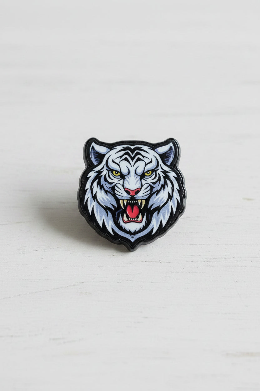 A small tiger head acrylic bead with a white and gray feline face, black outlines, yellow eyes, and a red tongue.