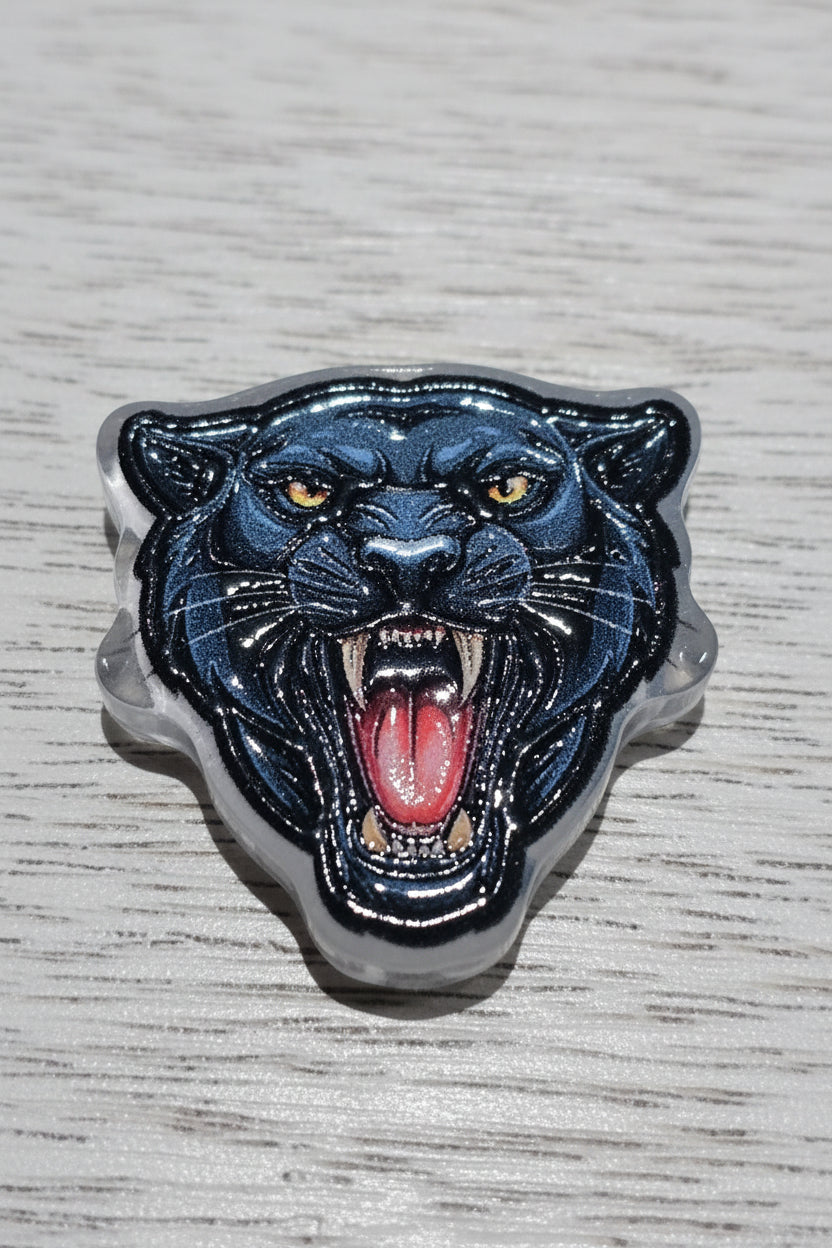 A glossy black  acrylic beadd with a red tongue and yellow eyes.