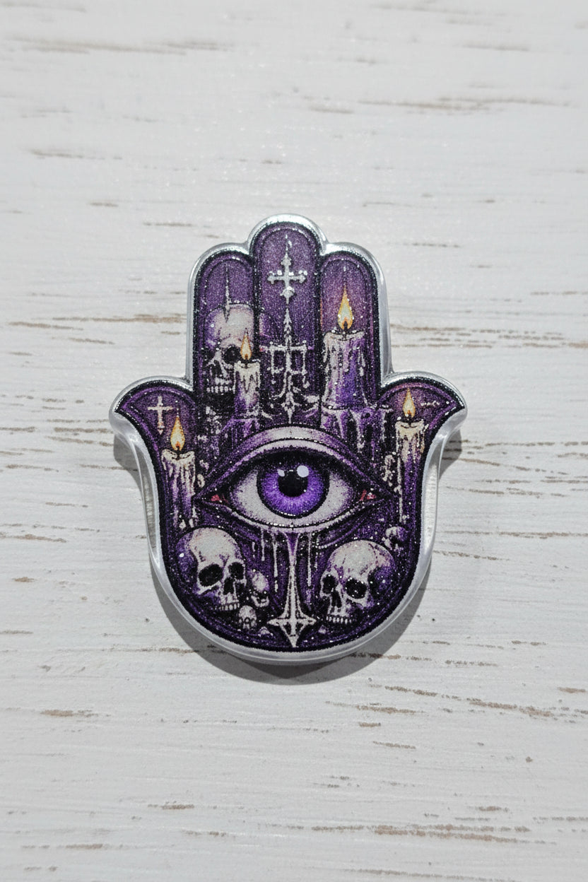 A Hamsa hand bead featuring a gothic cathedral design with a central eye, purple glitter, candles, and skulls.