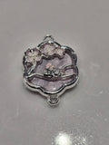 A silver-toned enamel charm featuring a sleeping bunny under purple cherry blossoms.