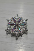 A silver snowflake-shaped bead  embellished with iridescent rhinestones and clear crystals