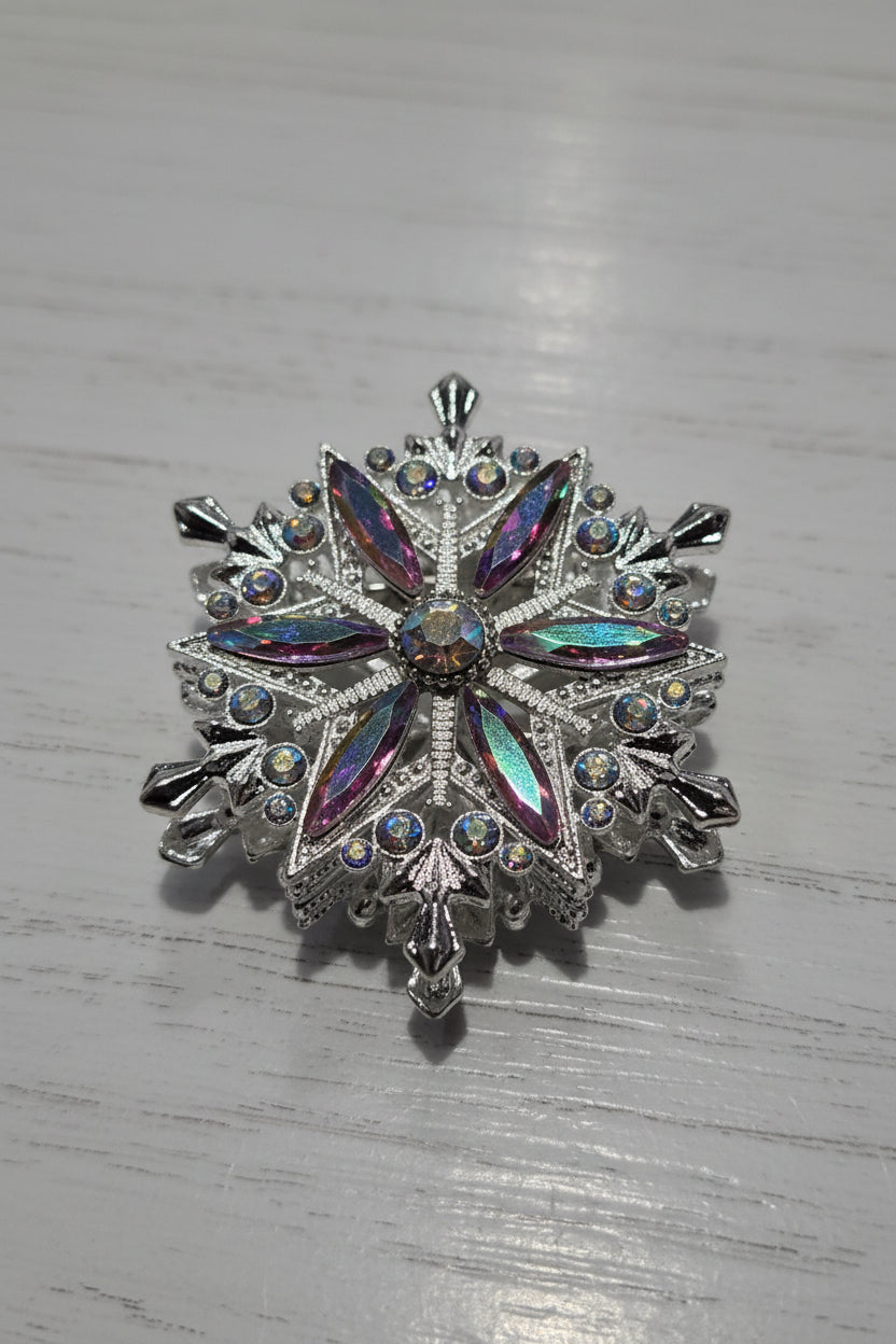 A silver snowflake-shaped bead  embellished with iridescent rhinestones and clear crystals