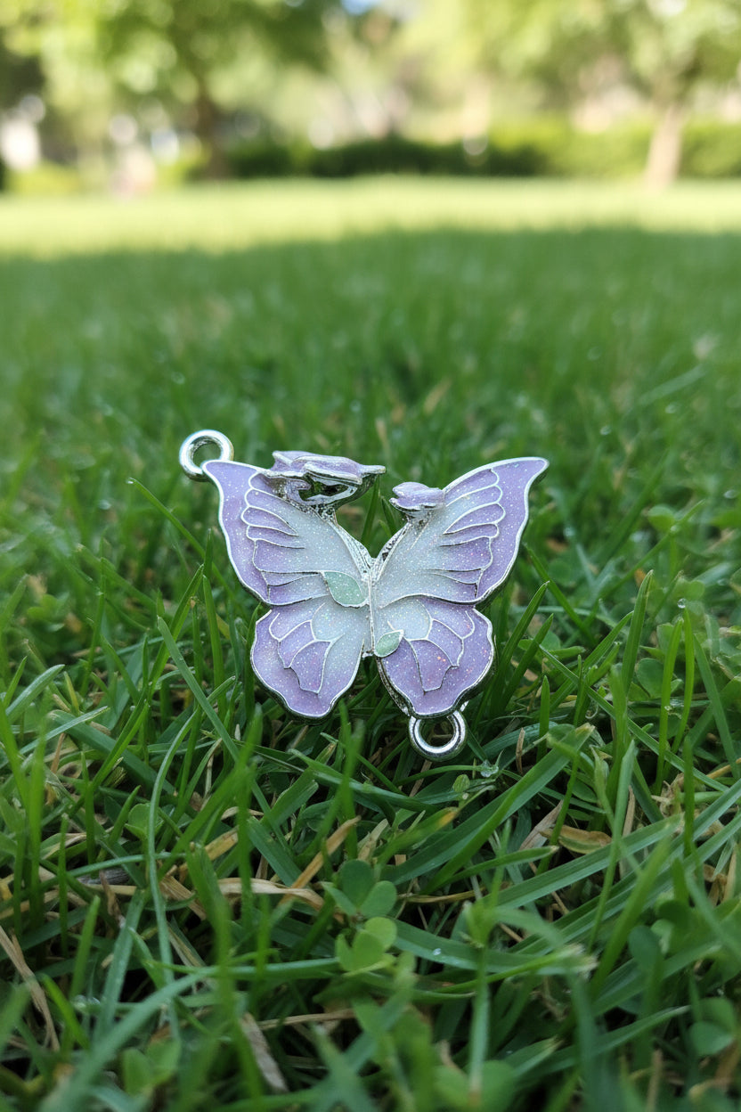 A butterfly-shaped jewellery charm with lavender purple and white textured wings.