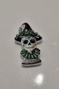 A Day of the Dead sugar skull bead wearing a black witch hat and a green ruffled collar.