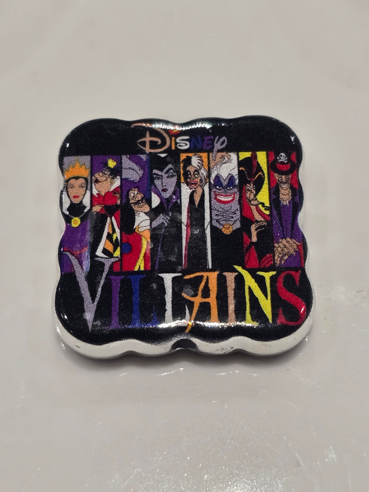 A Villains bead featuring a black background with colorful illustrations of villains and the word 'Villains' in multicolored letters.