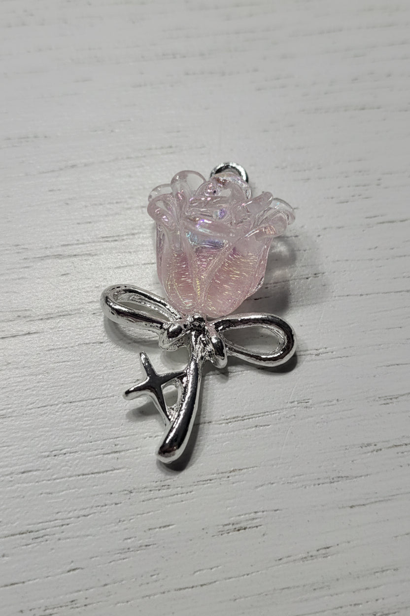 A silver-toned rose pendant featuring a small iridescent pink rose.