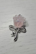 A silver-toned rose pendant featuring a small iridescent pink rose.