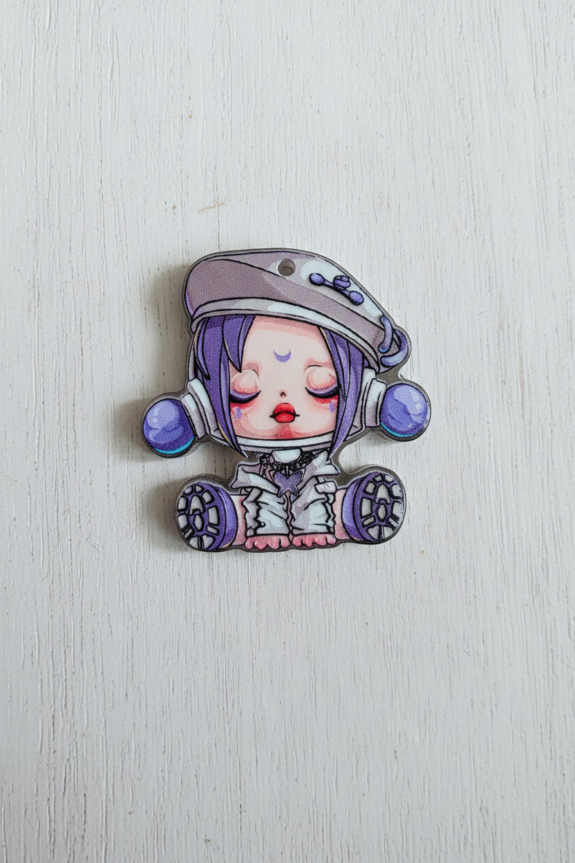 A small illustrated acrylic bead featuring a sleeping anime-style character with purple hair, a white outfit, and purple accents.