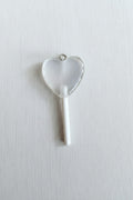 A heart-shaped translucent lollipop pendant with a white stick.