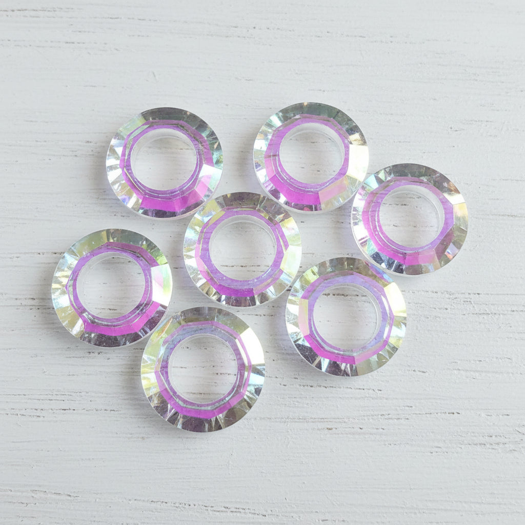 Five round iridescent glass ring beads with a pink inner ring.