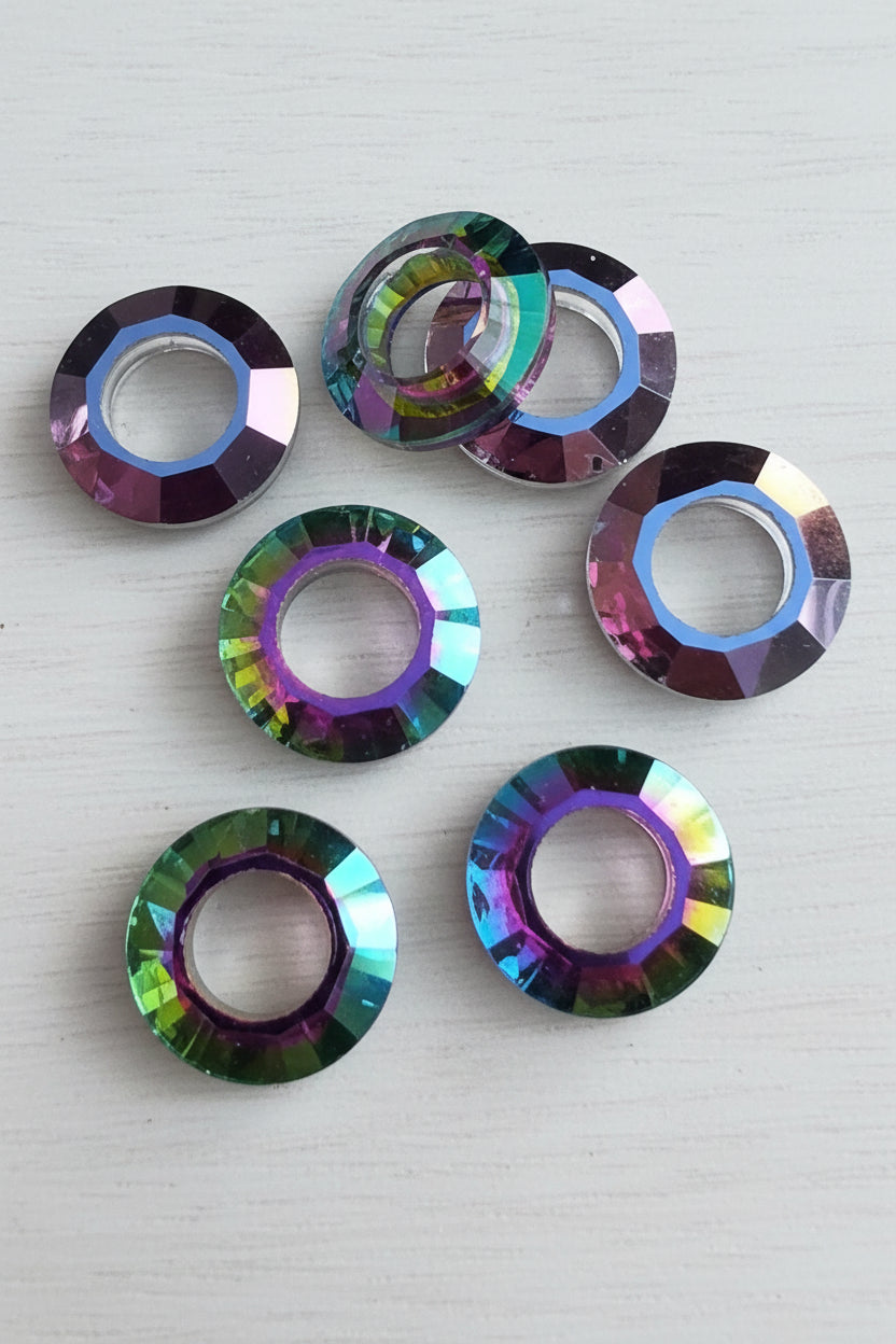 Five faceted iridescent glass beads with a double-ring design.