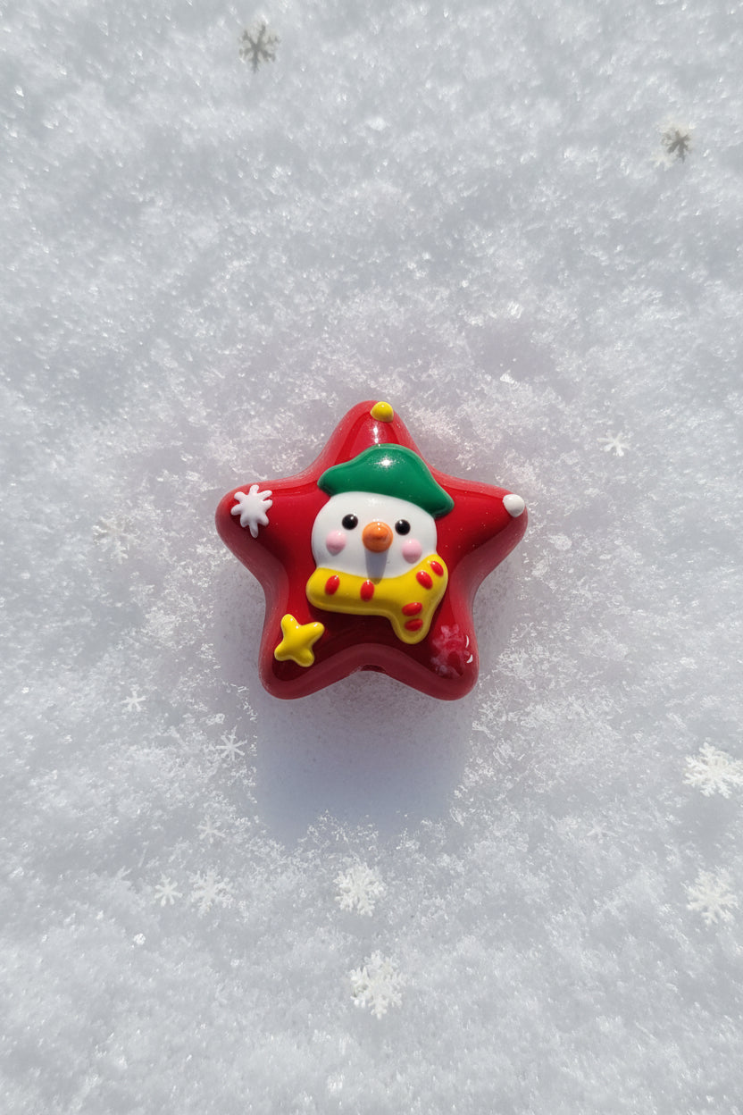A red star-shaped Christmas bead featuring a cute snowman wearing a green hat and yellow scarf